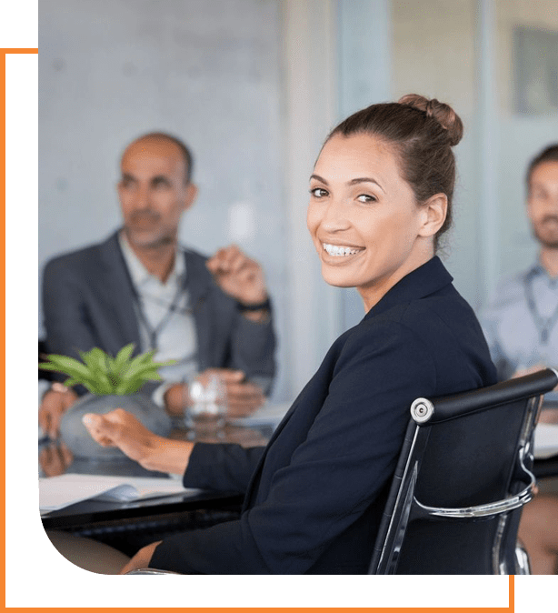 A woman sitting in front of other people at an office meeting.