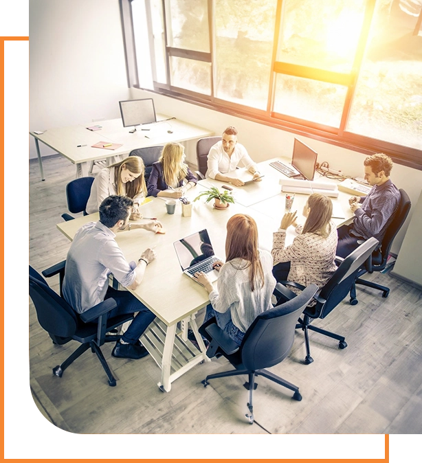 A group of people sitting at tables in an office.